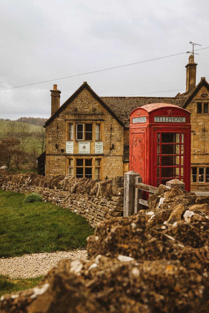 quaint cotswolds village with red telephone box